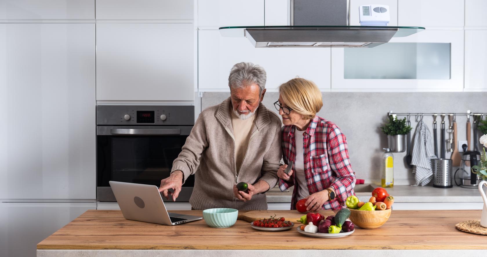 Dos personas en una cocina consultando un portatil