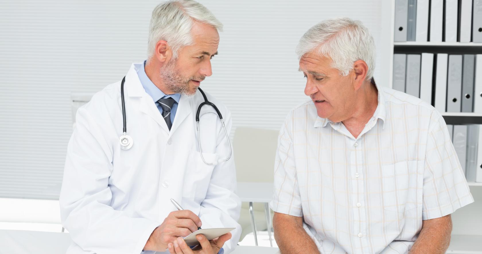 Un doctor junto a un paciente tomando notas