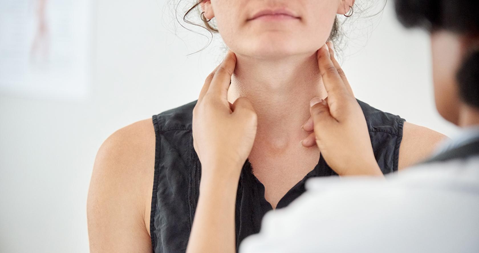 Doctora examinando el cuello a una paciente