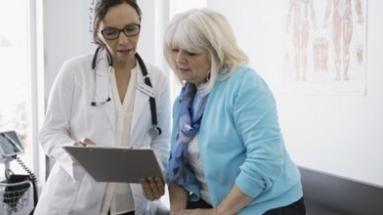 Una mujer mayor mirando unas pruebas con su médico