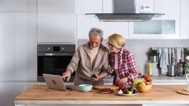 Dos personas en una cocina consultando un portatil