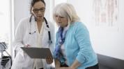 Una mujer mayor mirando unas pruebas con su médico