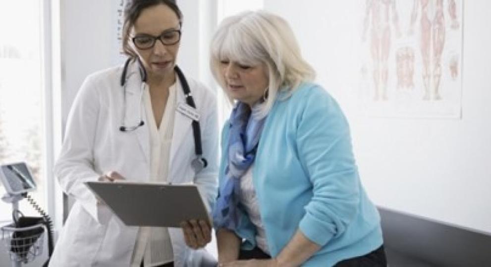 Una mujer mayor mirando unas pruebas con su médico