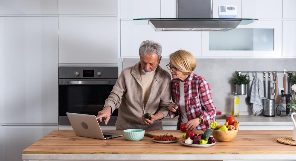 Dos personas en una cocina consultando un portatil