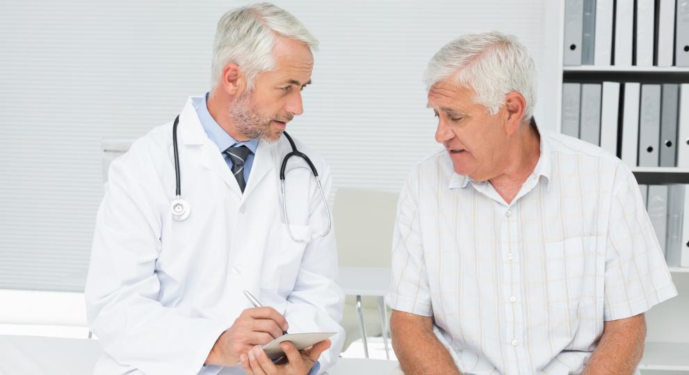Un doctor junto a un paciente tomando notas